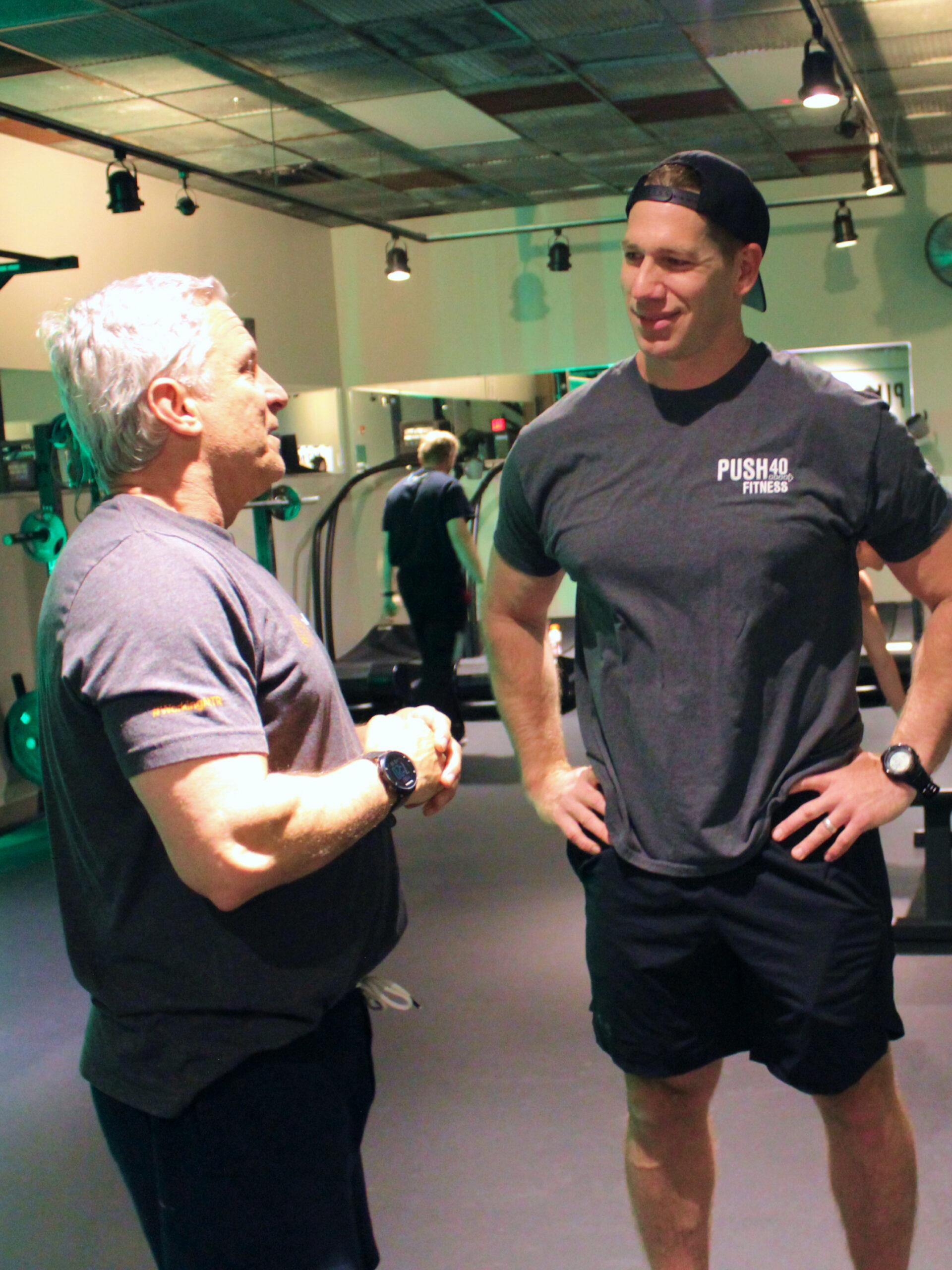 Coach Dan consulting with a member in the Push 40 Fitness studio.